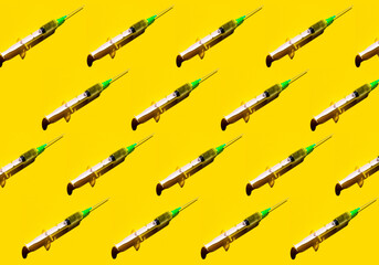 Pattern of a syringe on yellow background. Covid-19 vaccination concept and hope