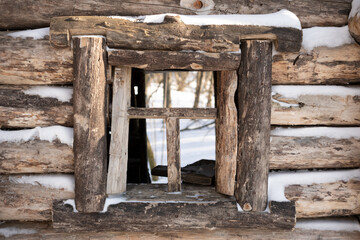 Fototapeta na wymiar Vintage fairy-tale window in a wooden hut in a snowy winter forest