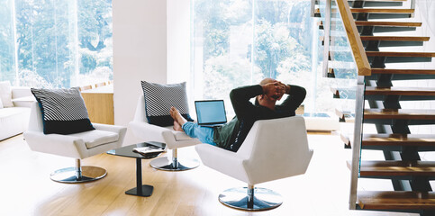 Man watching video on laptop while resting