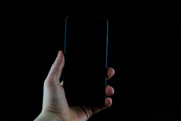 Phone in hand on a black background.