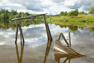 Summer landscape. Amazing view of the dilapidated raft in the lake, Russia.