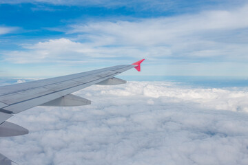 view from airplane window with white cloud and blue sky