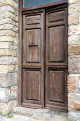 Fototapeta na wymiar massive brown wooden door in a massive brown stone building