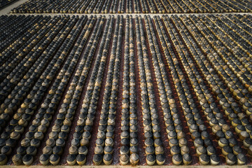 Traditional soy sauce factory, aerial view of the fermented field with numbers of earthen jars on the ground, where soya beans are fermented to produce the soy sauce which is used in Chinese cooking