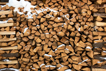 Stacks of firewood with snow. Pile of Firewood for the winter