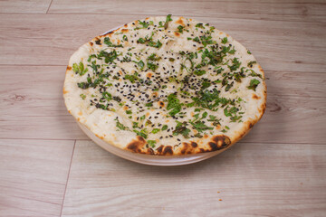 indian special flat bread also known as tandoori kulcha or naan, served in a white ceramic quarter plate
