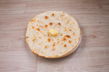 indian special flat bread also known as butter tandoori roti or naan, served in a white ceramic quarter plate