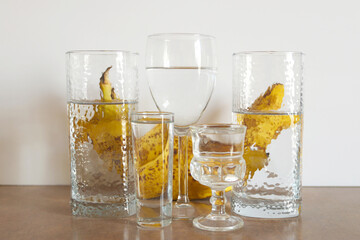 Bananas behind the glass of water. Reflection of bananas in a glass of water. Abstract food background.