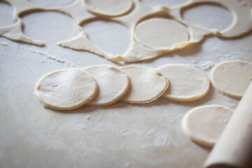 Variki with meat and mushrooms. They lie on the table. Dough.
