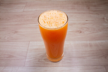 Orange juice in glass decanter with orange on wooden background. Horizontal orientation. Copy space.