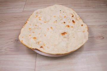 indian special flat bread also known as tandoori roti or naan, served in a white ceramic quarter plate