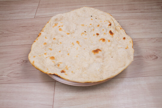 indian special flat bread also known as tandoori roti or naan, served in a white ceramic quarter plate