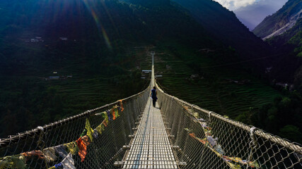 Girl crossing New Bridge: the longest suspension bridge in Himalaya mountain range in Nepal