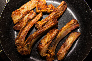 appetizing fried ribs in a non-stick frying pan.