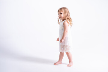 cute child blonde girl in white dress on white background