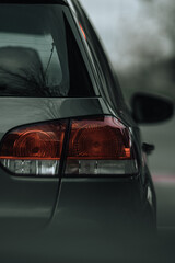 Car on the road closeup of back light in natural tones focus on tail-light turned off