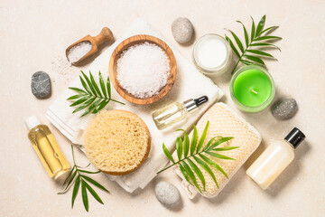 Fototapeta na wymiar Spa product composition with palm leaves, towel and cosmetic at stone table. Flat lay image.