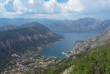 Fototapeta na wymiar Above view of Kotor bay and town with red roofs, surrounded by mountains. Famous picturesque place, breathtaking view, travel concept.
