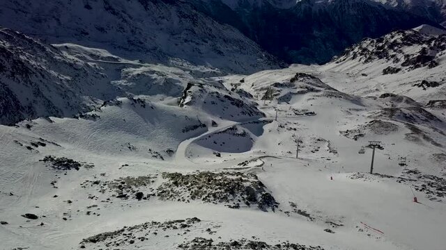 View of Cable car funitels scattered across barren snowy landscape in Val Thorens, French Alps - Aerial Fly over shot