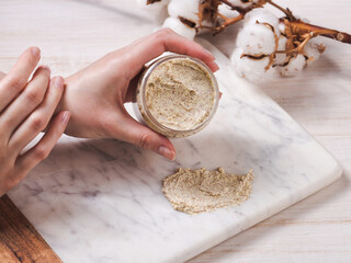 Natural body scrub on marble background. Cosmetic face cream container with care cruelty-free product. Flat lay, top view