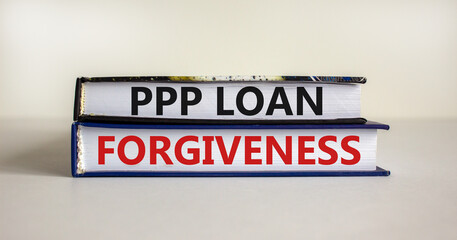 PPP, paycheck protection program loan forgiveness symbol. Concept words PPP, paycheck protection program loan forgiveness on books on a white background. Business, PPP loan forgiveness concept.