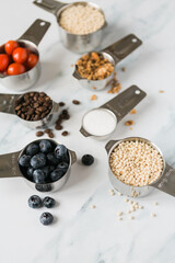 Set of silver measuring cups with food and ingredients inside
