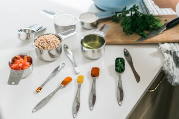 Set of different sized measuring cups and spoons on kitchen counter