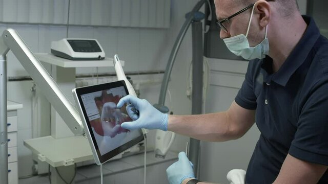 The doctor examines the 3D model of the jaw. A dentist examines a digital image of teeth on a monitor. Modern technologies in medicine and dentistry.