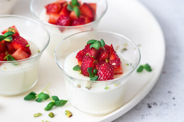 Healthy dessert of natural yogurt with strawberries and pistachios
