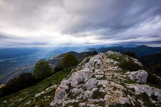Sunlight beaming through clouds over Mare De Deu Del Mont, La Garrotxa, Girona, Catalonia, Spain