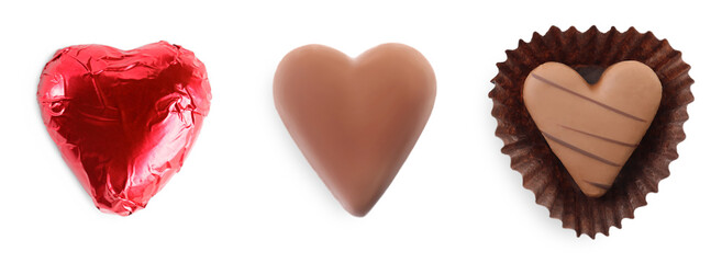 Set with delicious heart shaped chocolate candies on white background, top view. Banner design