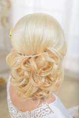 Bride's hairstyle close up. A girl in a white dress preparing for a wedding ceremony.