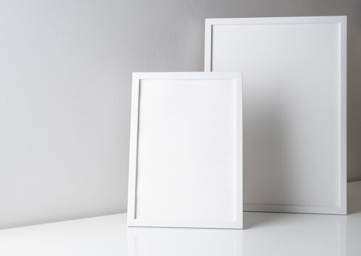 Mock up simply and modern white poster  frames two size on  white table and cement wall background