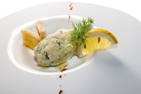 creamy cod, typical Venetian appetizer, called "baccal&agrave; mantecato" in a white dish with lemon slice and toasted bread