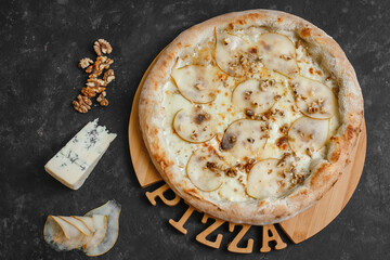 Homemade pizza with pear, gorgonzola, walnuts and honey on a dark background. Top view, side view