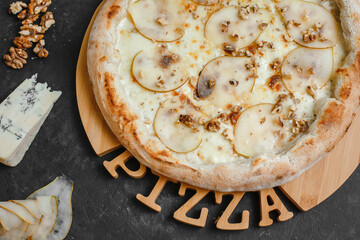 Homemade pizza with pear, gorgonzola, walnuts and honey on a dark background. Top view, side view