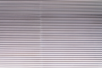 Obraz premium The texture of the wall is made of metal coating of huge aluminum plates of relief shape with horizontal notches. A variety of metal siding close-up