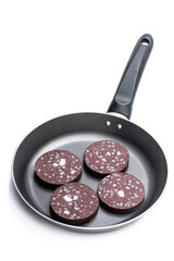 Traditional black pudding sausage slices in frying pan isolated on white