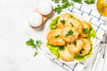 Chicken cutlet in white plate served at white stone table. Top view with copy space.
