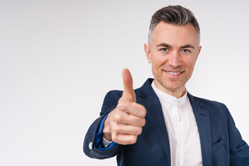 Close up portrait of a nice-looking middle-aged businessman showing thumb up isolated in white background