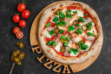 Homemade pizza with bacon and spicy jalapeno, tomato sauce, mozzarella and parsley on a dark background. Top view, side view