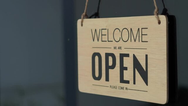 Cafes or restaurants and businesses reopened after the corona quarantine ended.
The man's hand is changing the sign from closed to open.