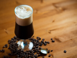 A glass of dark craft beer porter or stout, roasted coffee beans. Craft beer with coffee copy space