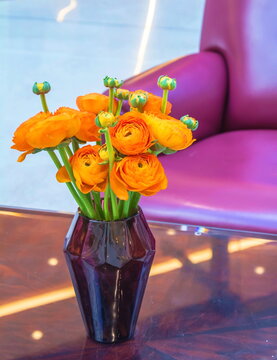 A Bouquet Of Bright Orange Flowers Is In A Vase On The Table