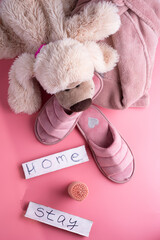 cozy home set with slippers and toy dog  against pink background. concept composition