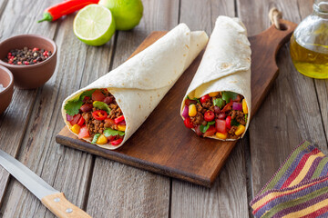 Burritos with meat, beans, corn, tomatoes, onions and chilli. Mexican food. Recipe.