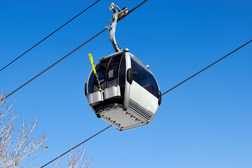 Obraz premium cableway cabin in a ski resort against the blue ski