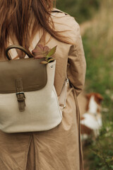 girl in a beige coat with a backpack close-up