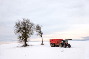 A red tractor crosses a snow-covered Zen landscape with a tree - French Jura