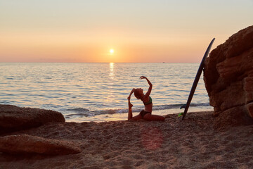 Yogi woman practicing yoga on seashore. Meditation idea. One Legged King Pigeon exercise. Eka Pada Rajakapotasana pose.
